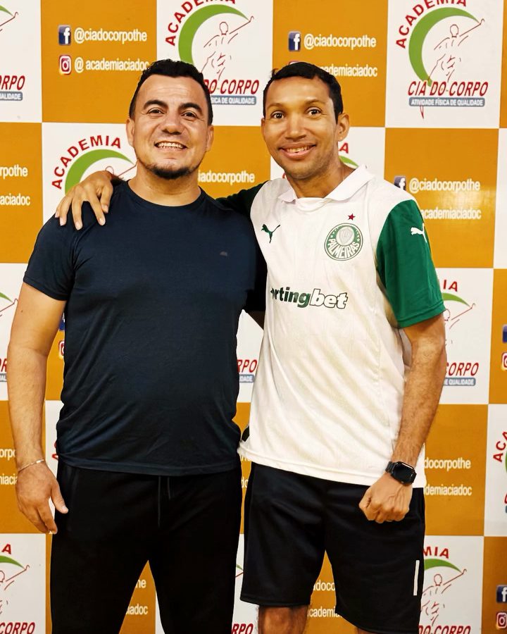 O Nilberto e o aluno abraçados e sorrindo na academia.