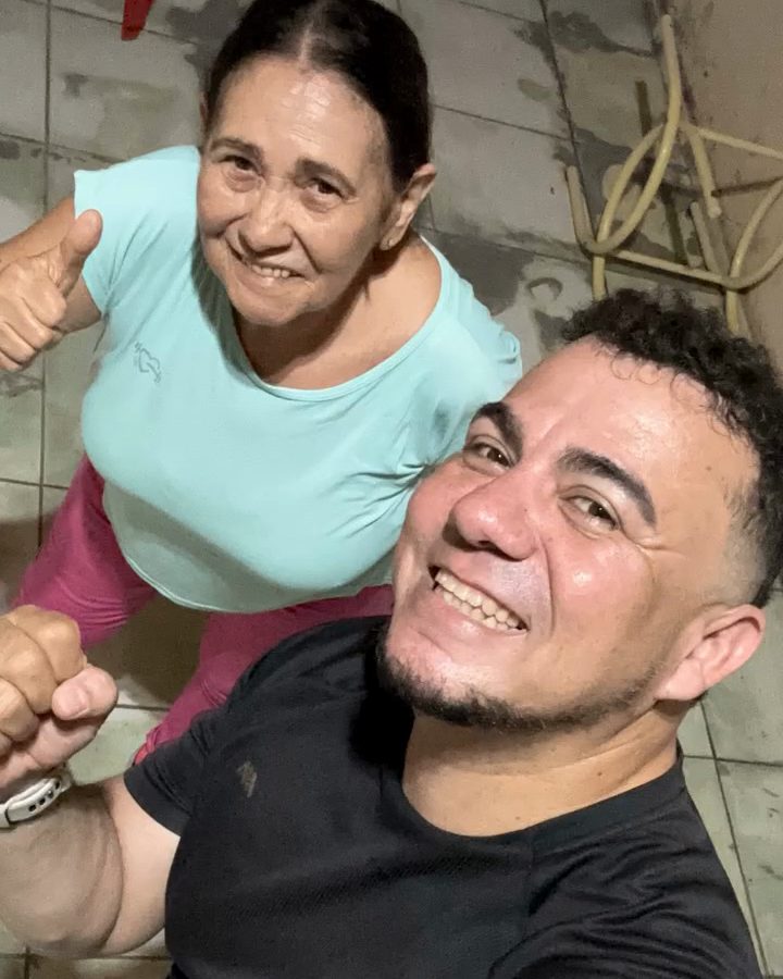 O Nilberto e uma aluna sorrindo juntos depois do treino, com o polegar para cima.